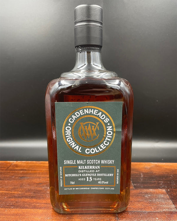 Bottle of Cadenheads Original Collection Kilkerran Single Malt Scotch Whisky on a wooden surface with a gray background