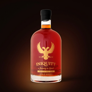 A bottle of Iniquity Gold Series aged whiskey with amber liquid, a gold double headed pheonix logo, and a black cap, centered against a dark brown background.